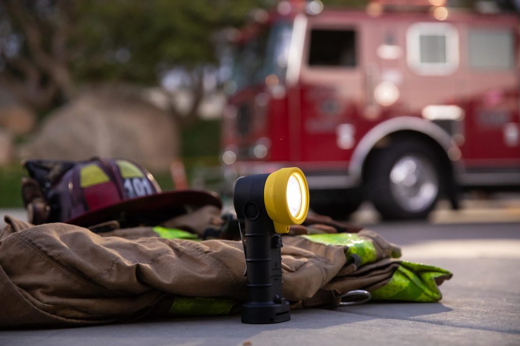 FoxFury BTS with helmet and turnout in front of a fire truck