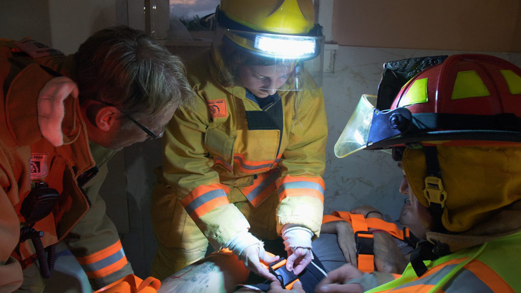 Firefighters with FoxFury headlamps work on patient