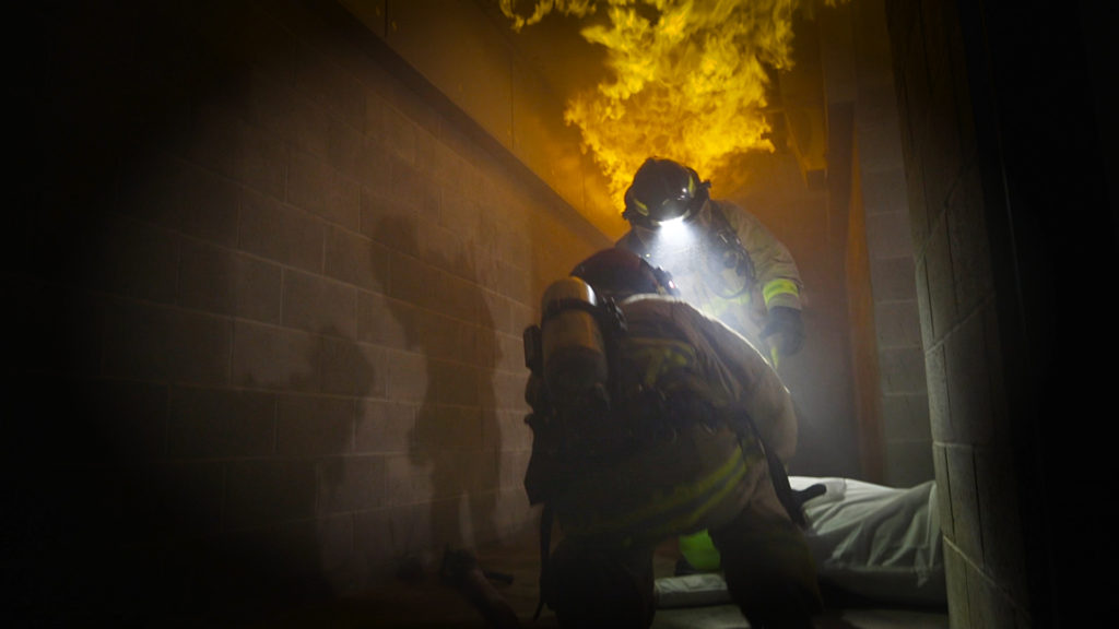 Firefighters rescuing a victim in structure fire training